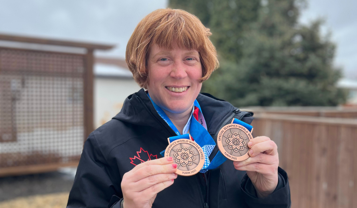 Jenny smiles with her two bronze medals in her backyard.