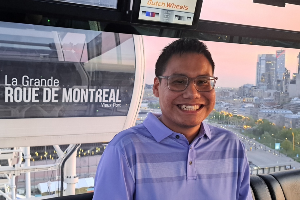 Dante on a ferris wheel with the Montreal skyline in the background.
